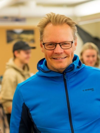 Henrik Henrik Karlsson Holmer - äventyrslärare. På bilden är en glad Henrik med elever i bakgrunden.