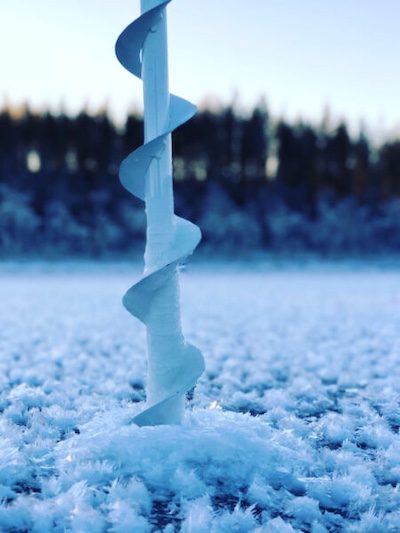 Bilden föreställer en isborr i isen och snökristaller.