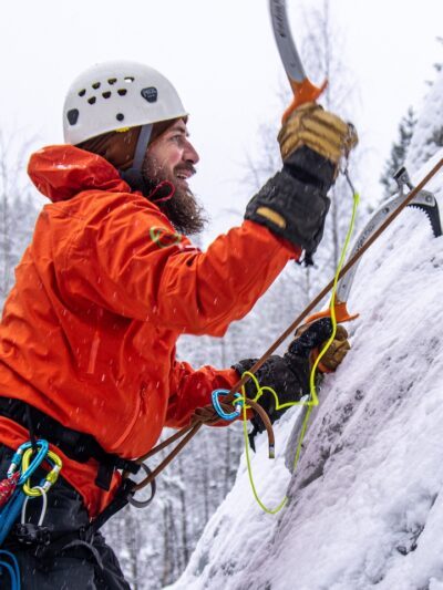 Josef Nordahl - äventyrslärare. På bilden klättrar han uppför ett snötäckt berg, under en lektion i klättring.